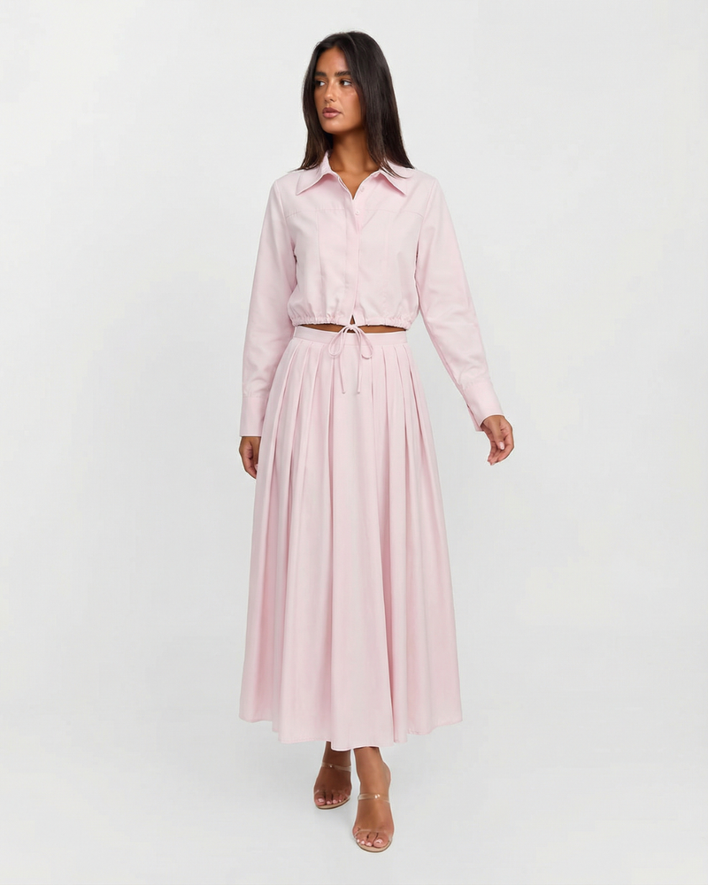 Woman wearing a light pink dress with a belt on a white background